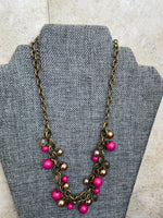 Petra-Cute short necklace, with pink and transparent beads and its chain is brass or dark gold